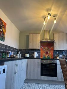 een keuken met houten kasten en een schilderij van een tijger bij Oaklodge House in Leyburn