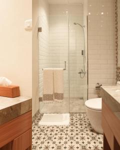 a bathroom with a glass shower and a toilet at BUMINAKURA in Bandung