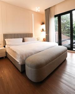 a bedroom with a large bed and a large window at BUMINAKURA in Bandung