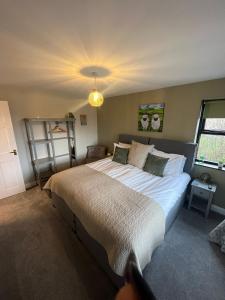 een slaapkamer met een groot bed en een raam bij Oaklodge House in Leyburn