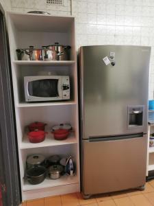 a refrigerator with a microwave and some pots and pans at Garden View Home in Brakpan