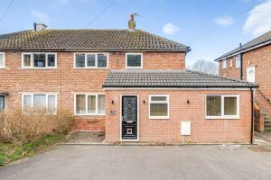 a red brick house with a black door at Peak District views and walks, 3 bed semi in Disley