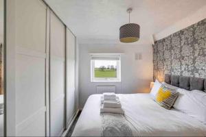 a bedroom with a large bed and a window at Peak District views and walks, 3 bed semi in Disley