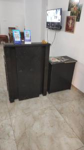 a black desk in a room with a tv at PLAY - Couple friendly Hotel in Greater Noida