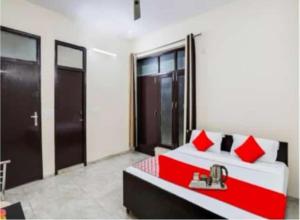 a bedroom with a red and white bed and a window at PLAY - Couple friendly Hotel in Greater Noida