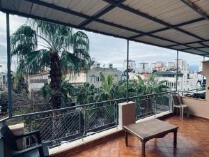 einen Balkon mit einem Tisch und einer Palme in der Unterkunft Luxury PentHouse İn Antalya in Antalya