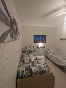 1 dormitorio con 2 camas y TV en la pared en Apartamento Céntrico Churriana en Churriana de la Vega