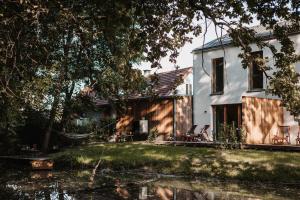 ein Haus mit einem Teich davor in der Unterkunft Wohnen am Flussufer - AM WASSER COMFORT in Kaindorf an der Sulm