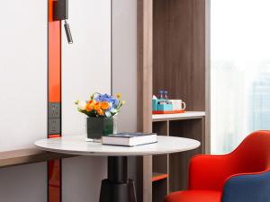 a table with a vase of flowers and a book at Holiday Inn Express Shenzhen Futian Center, an IHG Hotel in Shenzhen