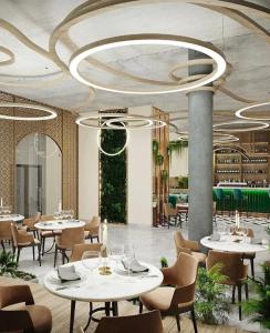 a restaurant with tables and chairs in a room at Жилой комплекс Гулдер 72 in Almaty