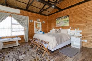 ein Schlafzimmer mit einem großen Bett und einem Schreibtisch in der Unterkunft Abendruhe Lodge in Pretoria