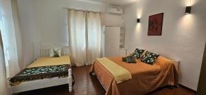 a small room with two beds and a window at Ground Floor Apartment near Pereybere Beach in Pereybere +6 photos