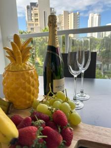 a bottle of wine and a bunch of fruit on a table at The Crest Apartments in Gold Coast