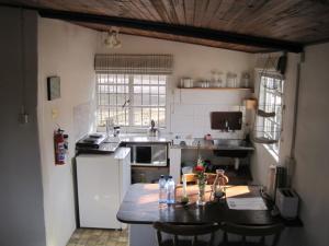 a kitchen with a table and a white refrigerator at Klondyke Cherry Farm in Matjiesrivier