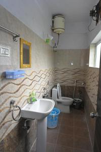 a bathroom with a sink and a toilet at Anyhour Stay in Gannavaram