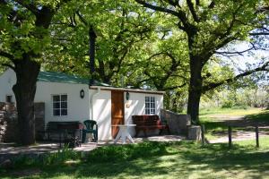 a white house with a picnic table and trees at Klondyke Cherry Farm in Matjiesrivier