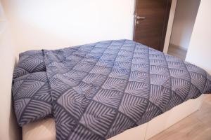 a bed with a blue and white comforter at Apartma Katja in Škofja Loka