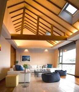 a living room with a ceiling with wooden beams at Ocean View Luxury Beach House - Enjoy Spring Cherry Blossoms, Beaches and BBQ at a Luxury Home in Shimoda