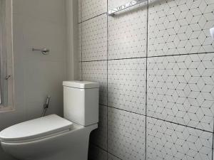 een witte badkamer met een toilet en een betegelde muur bij RB5: PrivateHouse 8pax,chatuchak,mrt,jodd fair in Ban Zong Katiam