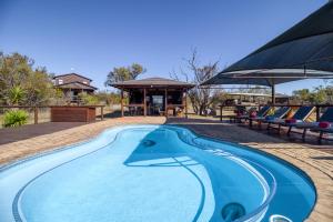 a swimming pool with a gazebo and a house at Abendruhe Lodge in Pretoria