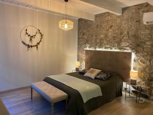 a bedroom with a bed and a wall with a clock at Le Bruit de l'eau (Chambre Boudoir) in Labeaume