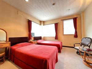 a hotel room with two beds and a mirror at リゾートハウス秋桜 in Ōtaki