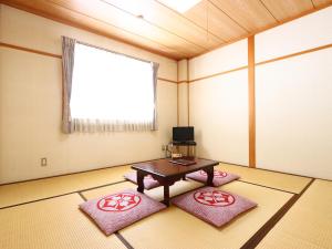 a room with a table and two red mats at リゾートハウス秋桜 in Ōtaki