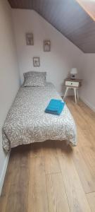 ein Schlafzimmer mit einem Bett mit einem blauen Buch darauf in der Unterkunft gîte la tanière de claire in Ségur