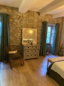 a bedroom with a bed and a dresser at Le Bruit de l'eau (Chambre Boudoir) in Labeaume