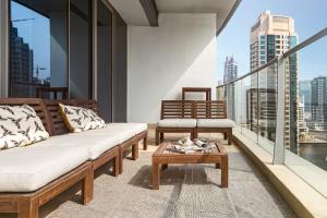 a balcony with a couch and a coffee table on a building at Frank Porter - Trident Grand in Dubai