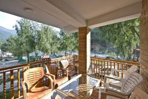 a balcony with chairs and a view of a street at Hotel Himalayan Classic, Manali in Manāli