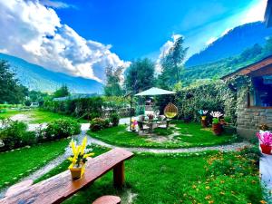 a garden with a bench and a table in the grass at Hotel Himalayan Classic, Manali in Manāli