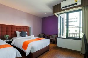 a hotel room with a bed and a window at Grandpink park hotel in Hat Yai