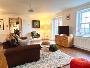 sala de estar con sofá y TV en Trossachs Barn & Cabin en Port of Menteith