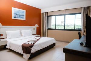 a hotel room with a bed and a window at Nipa Garden Hotel in Surat Thani