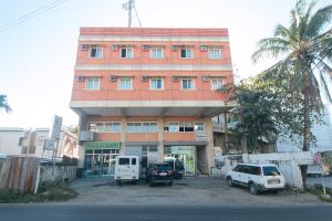 a building with cars parked in front of it at RedDoorz @ Asiana Pension Inn Mandaue City in Mandaue City