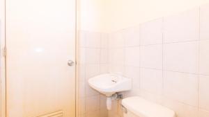 a white bathroom with a sink and a toilet at RedDoorz @ Asiana Pension Inn Mandaue City in Mandaue City +27 photos