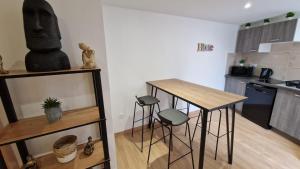 una cucina con tavolo e sgabelli in una stanza di maison neuve - le laos - a Les Ageux