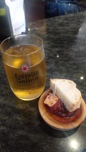 ein Sandwich auf einem Teller neben einem Glas Bier in der Unterkunft Ribeira Sacra 2 O Saviñao in Villasante