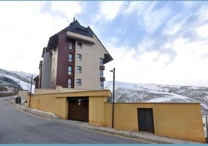a building on the side of a road with snow at Estudio Infinity con parking in Sierra Nevada