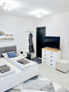 1 dormitorio con 2 camas, silla y cómoda en Spacious luxury studio with mountain view - SPA available, en Bansko
