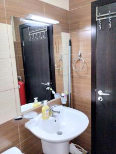Un baño con lavabo y ducha con espejo. en Spacious luxury studio with mountain view - SPA available, en Bansko