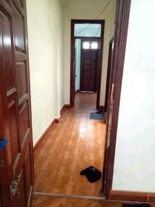 a hallway with a wooden floor and a door at 3BT home in Hanoi