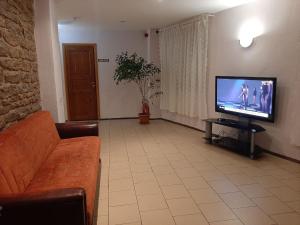 a living room with a couch and a flat screen tv at Rooms near the station in Narva