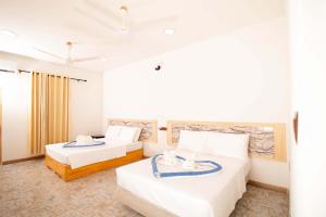 ein Hotelzimmer mit 2 Betten und Handtüchern darauf in der Unterkunft ONE SEASON THODDOO in Thoddoo-Atoll