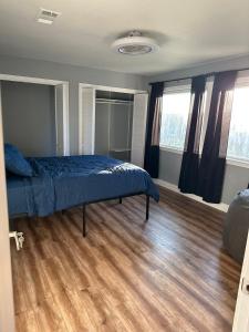 a bedroom with a bed and a wooden floor at Rooms at The Blue House in Austin
