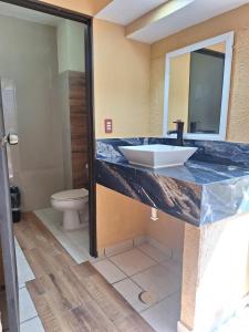 y baño con lavabo y aseo. en Hotel San Rafael, en Poza Rica de Hidalgo