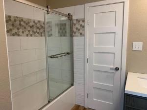 a shower with a glass door in a bathroom at Rooms at The Blue House in Austin