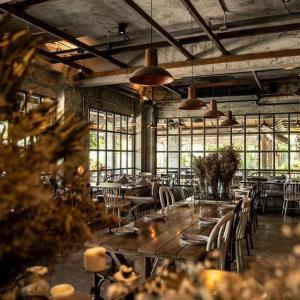 a large room with tables and chairs and windows at Nipa Garden Hotel in Surat Thani