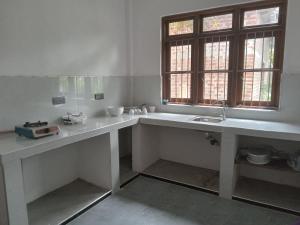 une cuisine blanche avec un évier et une fenêtre dans l'établissement Astral Residence, à Anurâdhapura